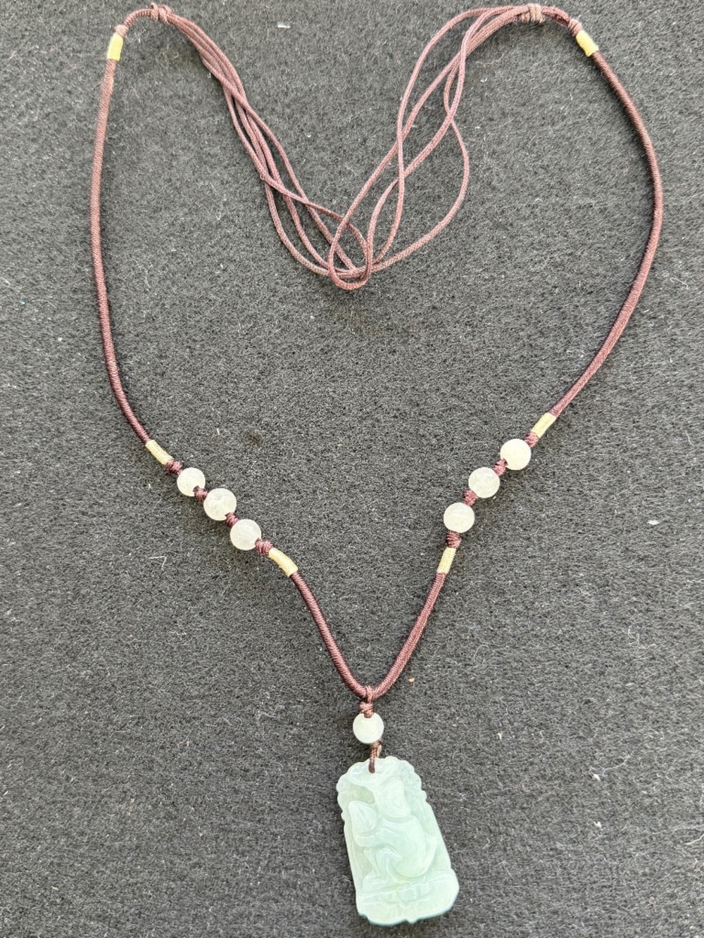 Jade/Jadeite adjustable pendant on a brown cord.